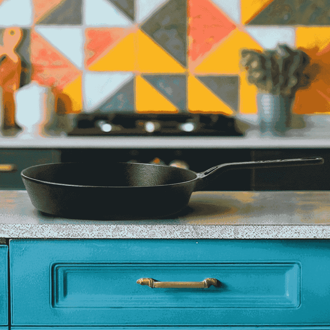 Roca Nix 24cm pre-seasoned black cast iron skillet on a kitchen counter with a colorful backsplash.