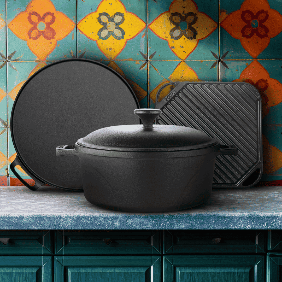Black cast iron cookware set on a kitchen counter with colorful tiled wall in the background