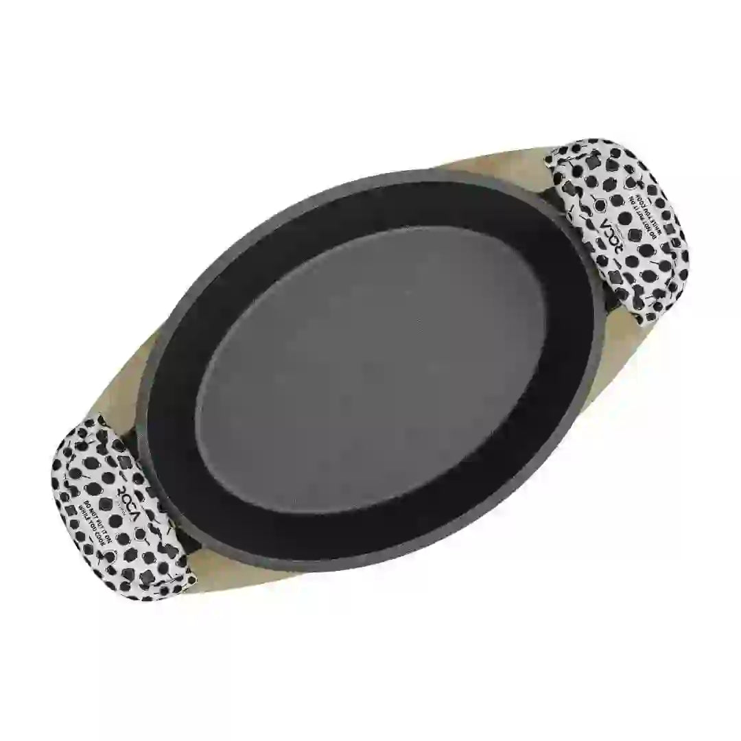 Roca Atlas cast iron oval pan on a wooden tray with patterned cotton handle sleeves.