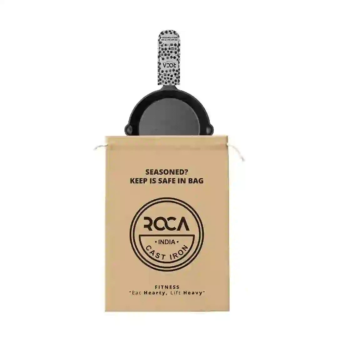 Roca 19cm cast iron skillet with a patterned handle sleeve and a branded tan cotton storage bag.