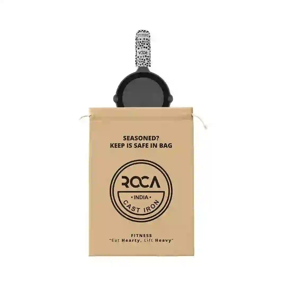 Roca 15cm cast iron skillet with a patterned handle sleeve and a branded cotton storage bag.