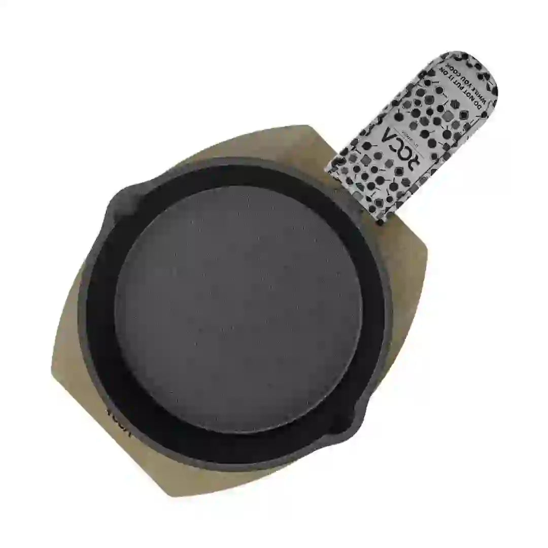 Roca Atlas 12.5cm cast iron skillet on a wooden tray with a patterned cotton handle sleeve.