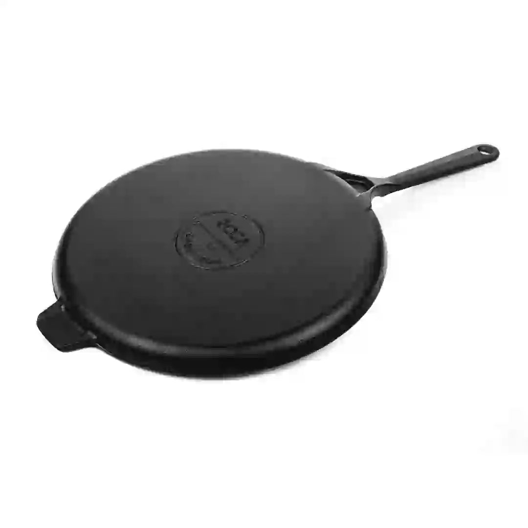 Bottom view of a 28cm Roca Europa cast iron dosa tawa with a long handle and helper tab.
