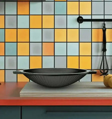 Roca Europa 20cm cast iron appachetty with side handles on a wooden board against a tiled wall.