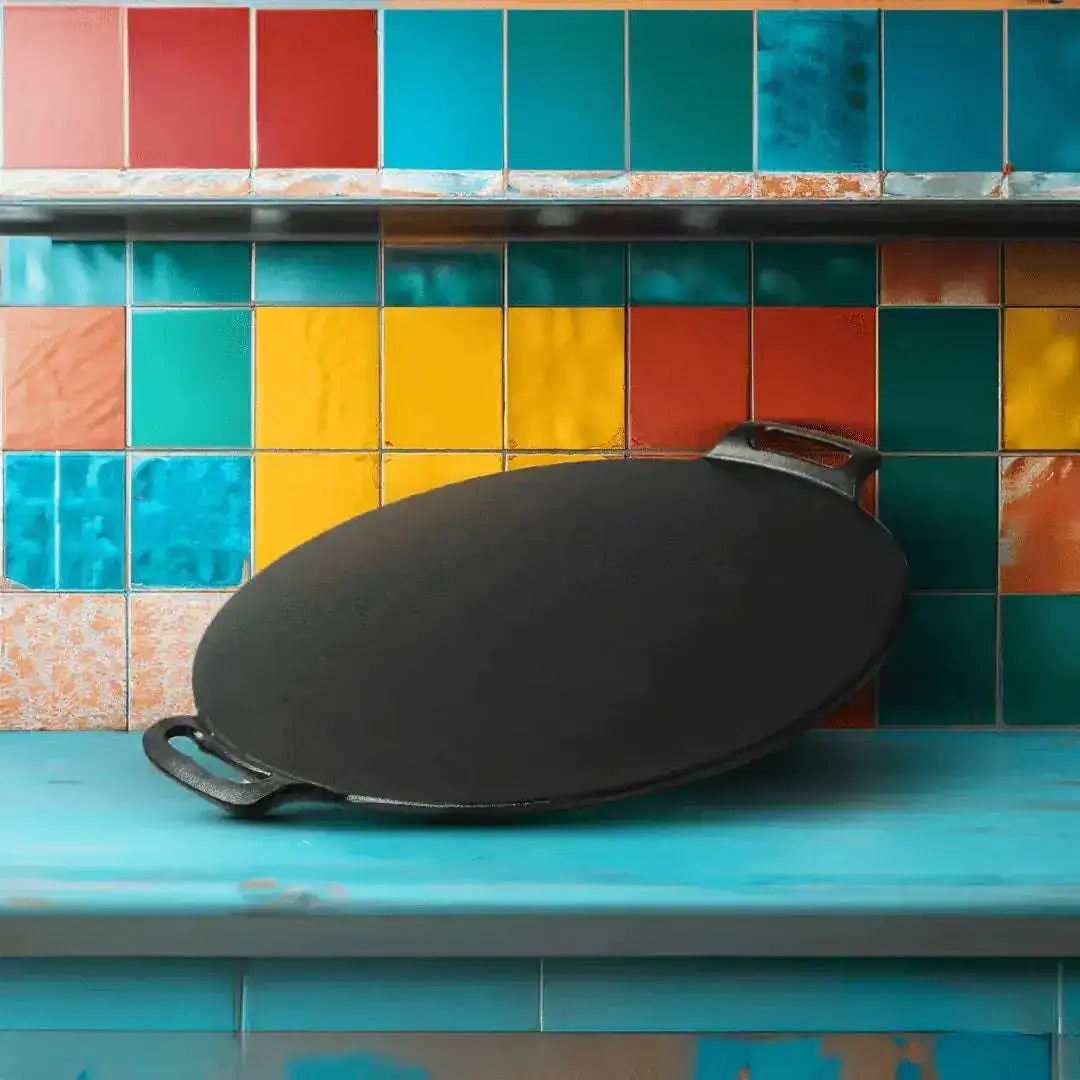 Black cast iron skillet on a blue countertop with colorful tiled wall in the background