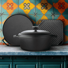 Black cast iron cookware set on a kitchen counter with colorful tiled wall in the background