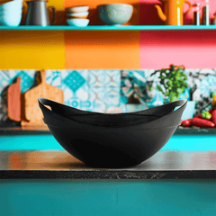 Black bowl on a colorful shelf with kitchen items