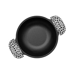 Black cast iron skillet with a patterned handle on a white background