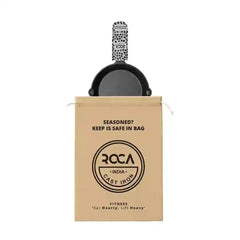 Roca 19cm cast iron skillet with a patterned handle sleeve and a branded tan cotton storage bag.