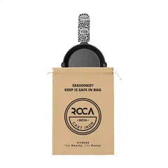 Roca 25cm cast iron skillet with a patterned handle sleeve and a branded tan storage bag.